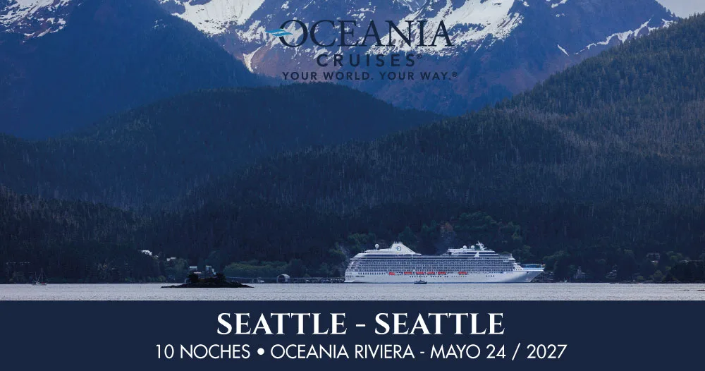 Oceania Riviera navegando frente a montañas nevadas y bosques de Alaska durante un crucero de 10 noches con salida y regreso a Seattle en mayo de 2027.