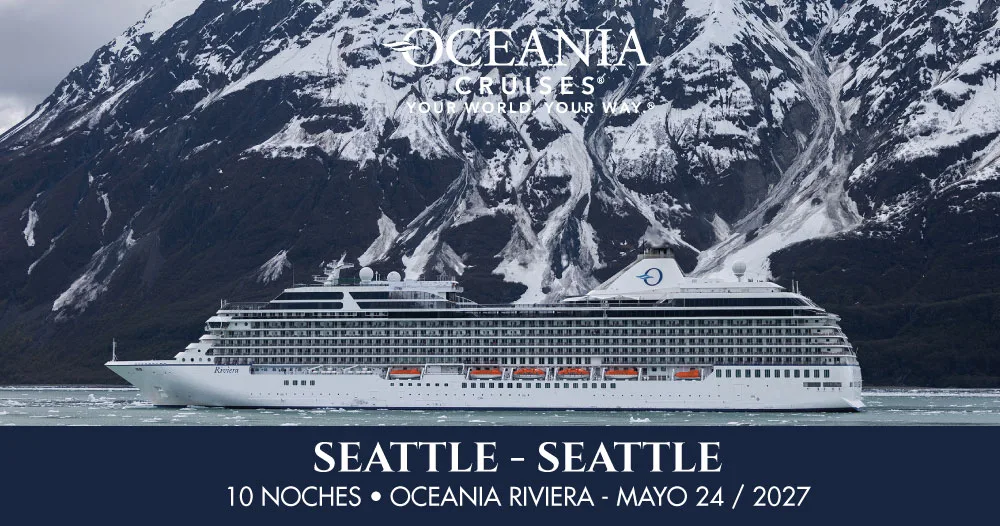 Oceania Riviera navegando frente a montañas nevadas de Alaska durante un crucero de 10 noches con salida y regreso a Seattle el 24 de mayo de 2027.